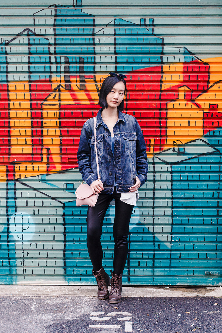 Denim leather outfit in front of a mural in Perth Australia.