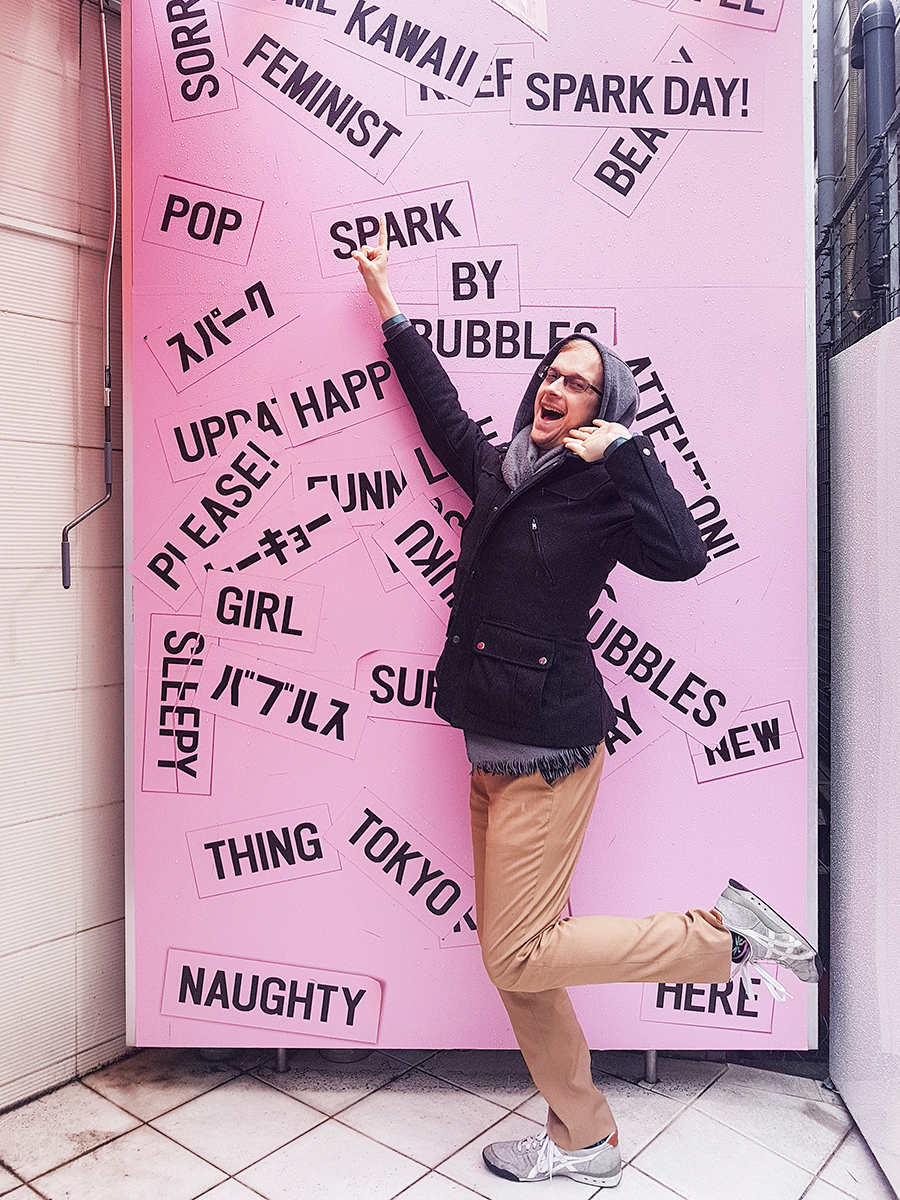 Ottie posing by a wordy pink wall at Spark by Bubbles, Tokyo.