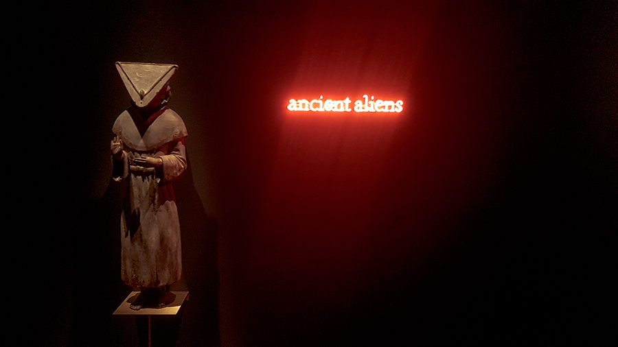 Prêtre JÔMON wood sculpture and Ancient Aliens neon sign by Laurent Grasso at the The Universe and Art: An Artistic Voyage Through Space exhibition, ArtScience Museum Singapore.