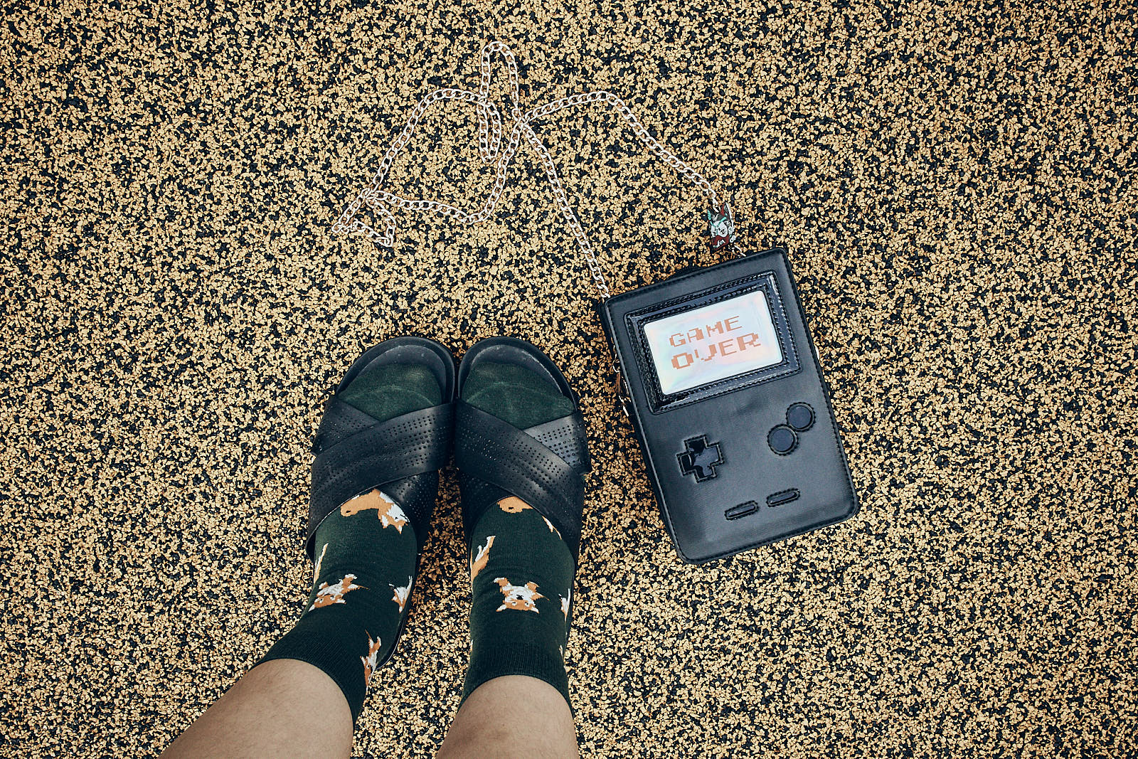 Puppy socks, black sandals, gameboy purse flatlay.